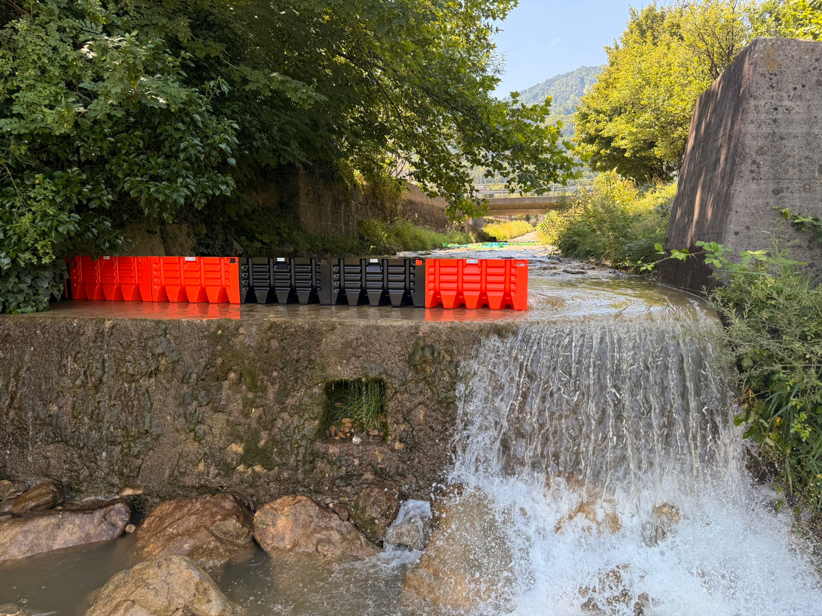 Beaver Flood Fence auf einer Wehrmauer, darunter stürzt das Wasser ab