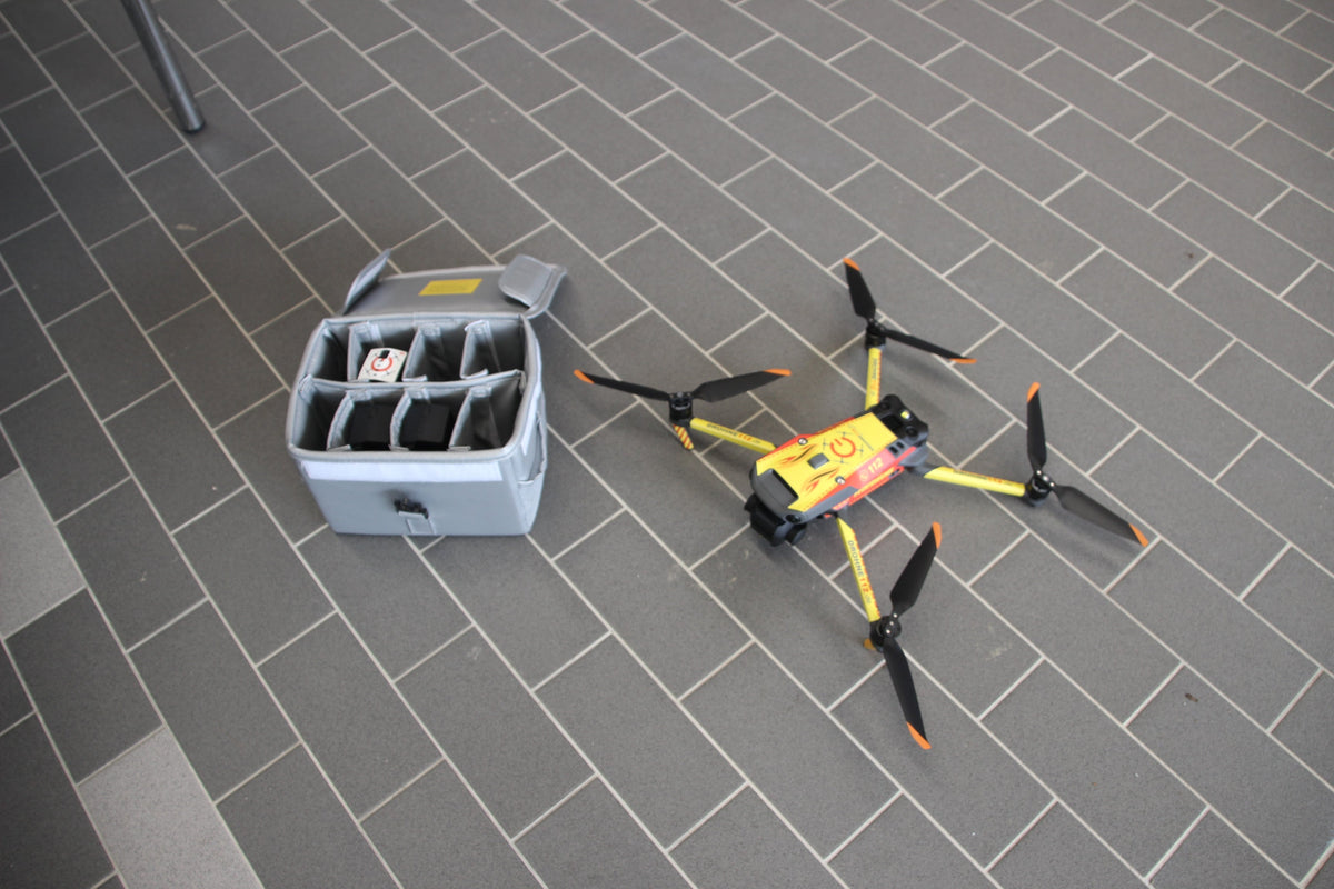 Vlitex Battery Safety Box L next to an FPV drone