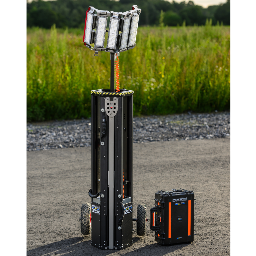 Baselight Lichtmast mit ausgefahrenem LED-Kopf neben dem separaten Akkukoffer auf einem Schotterplatz